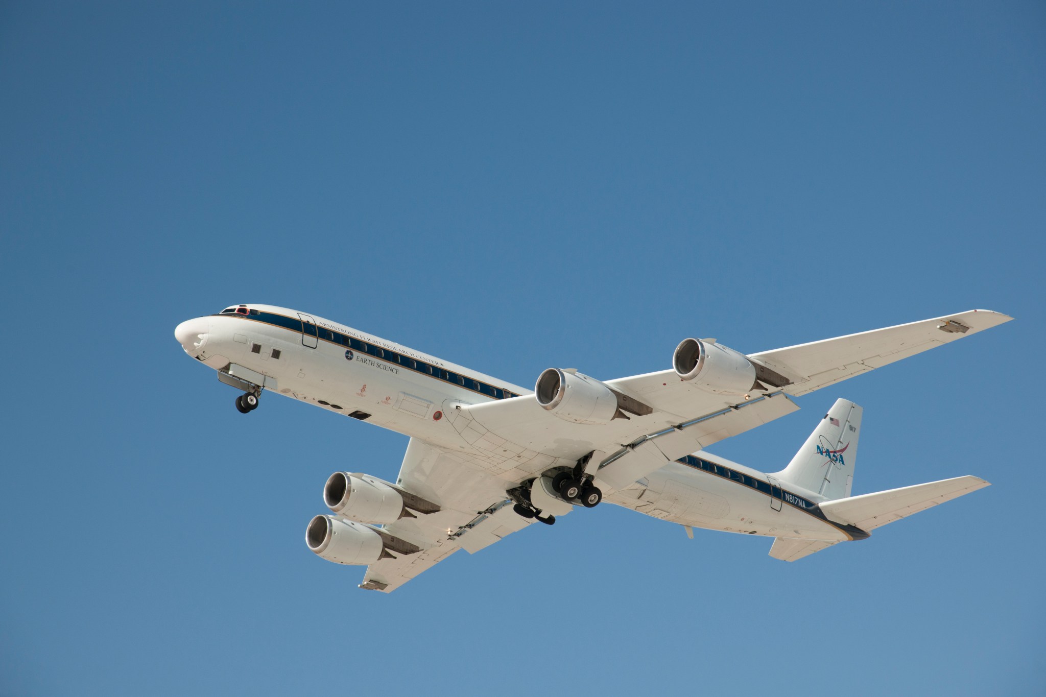 NASA DC-8 science aircraft in flight against clear blue sky.