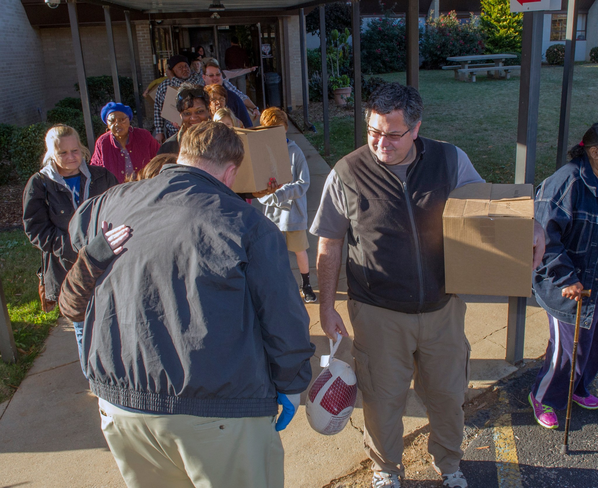 Volunteers from MArshall Center hand out turkeys at the Downtown Rescue Mission