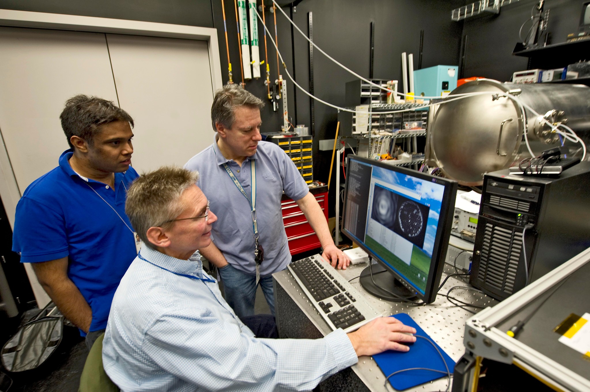 three men looking at a computer monitor showing the early version of the Visible Nulling Coronagraph