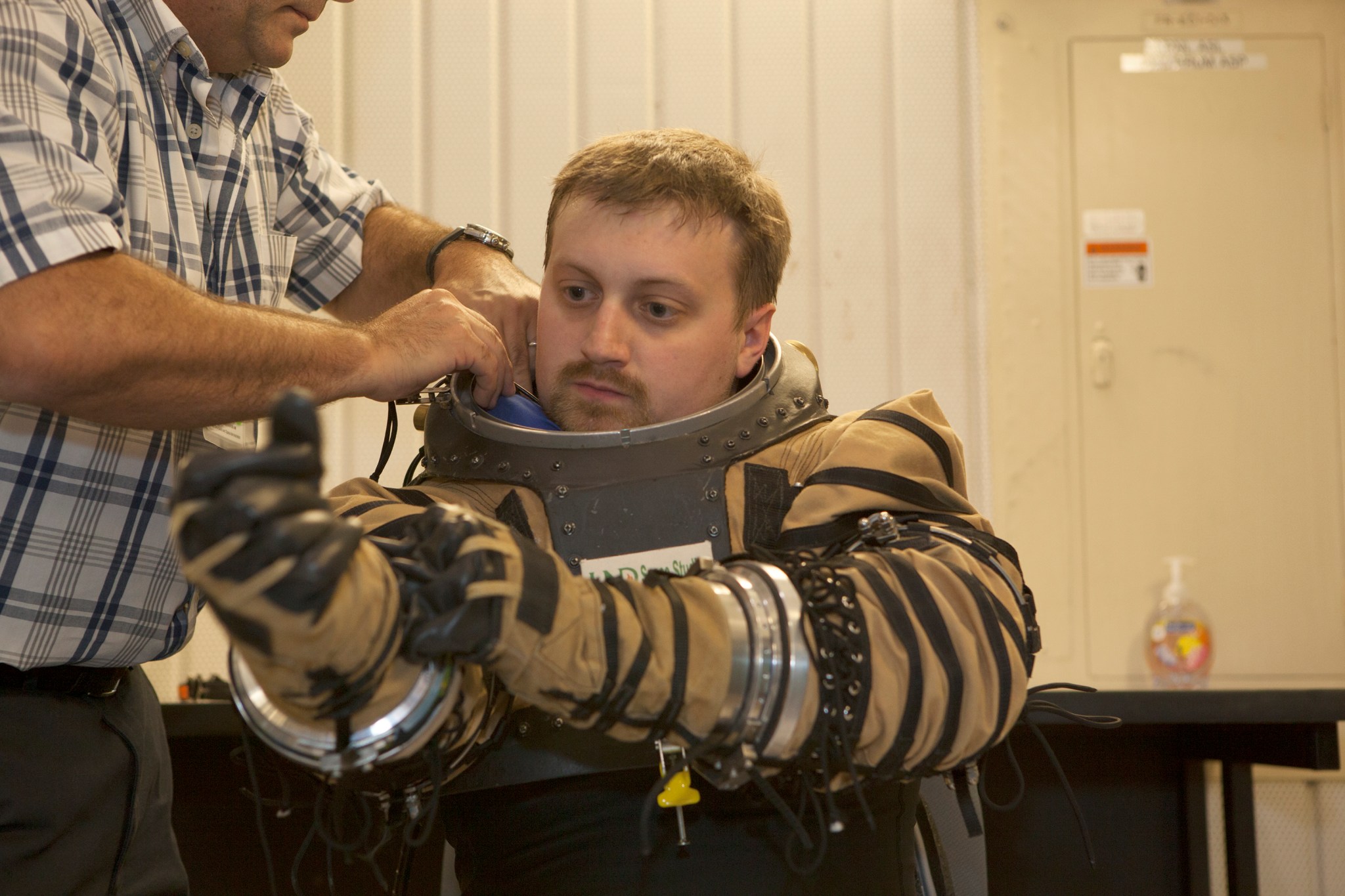 Spacesuit evaluator gets into spacesuit for testing.