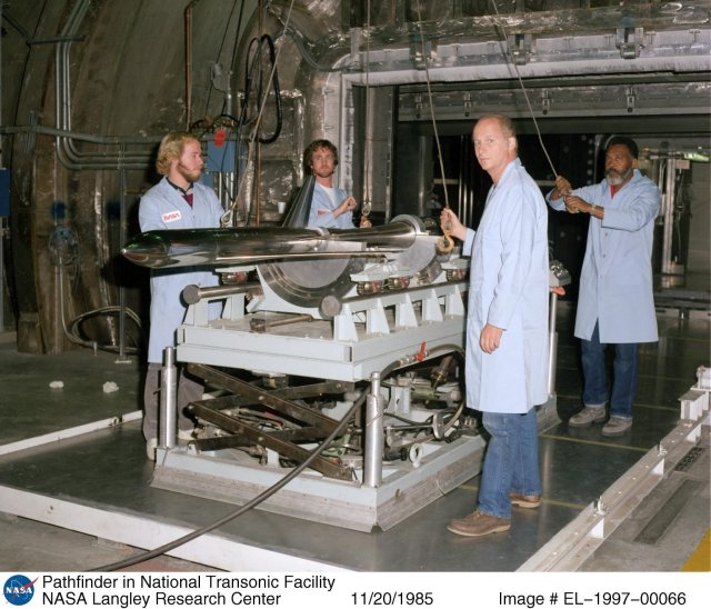 Four NASA employees loading a model into the test section.