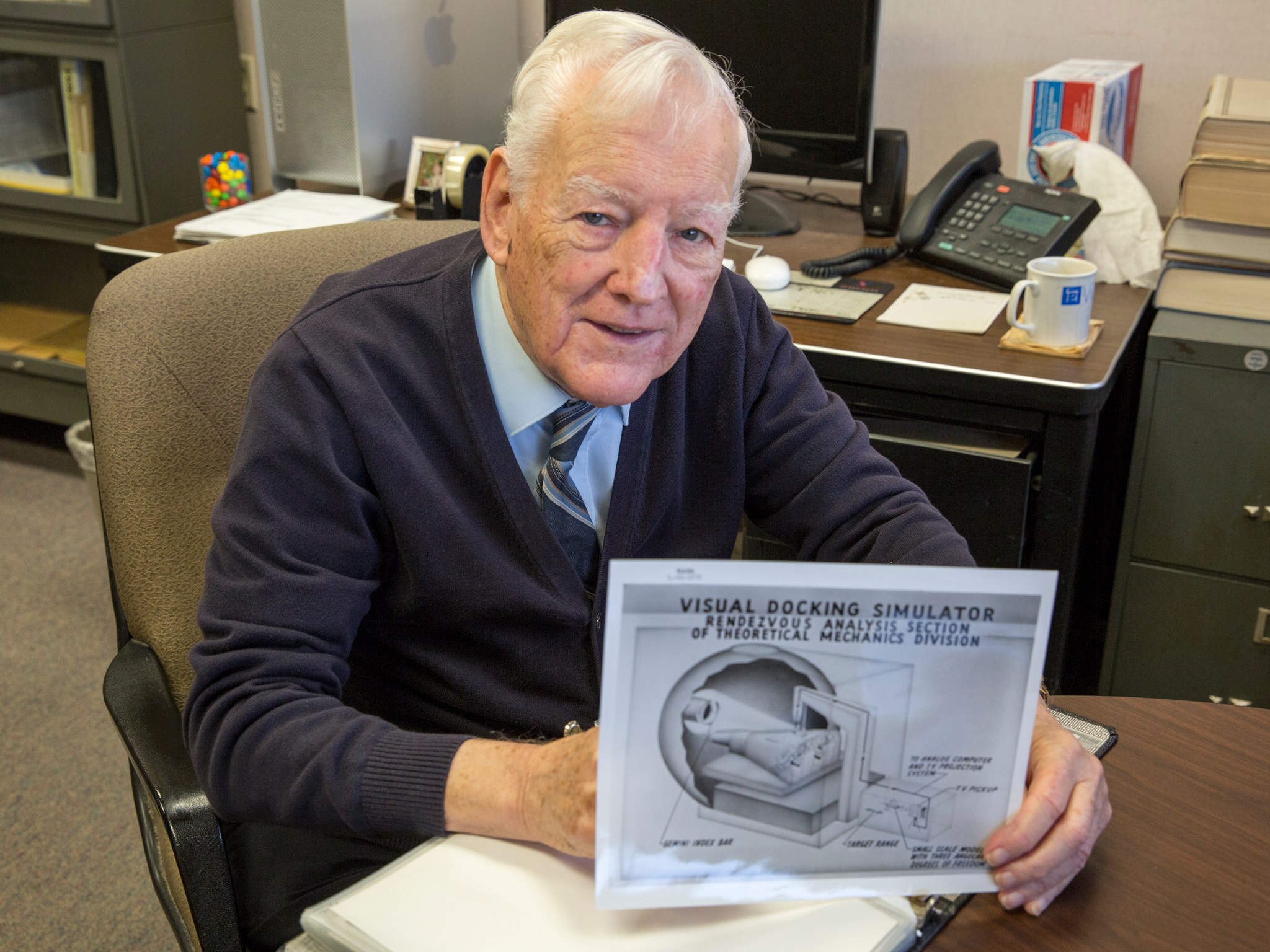 Don Riley holds a diagram explaining how the Visual Docking Simulator worked.