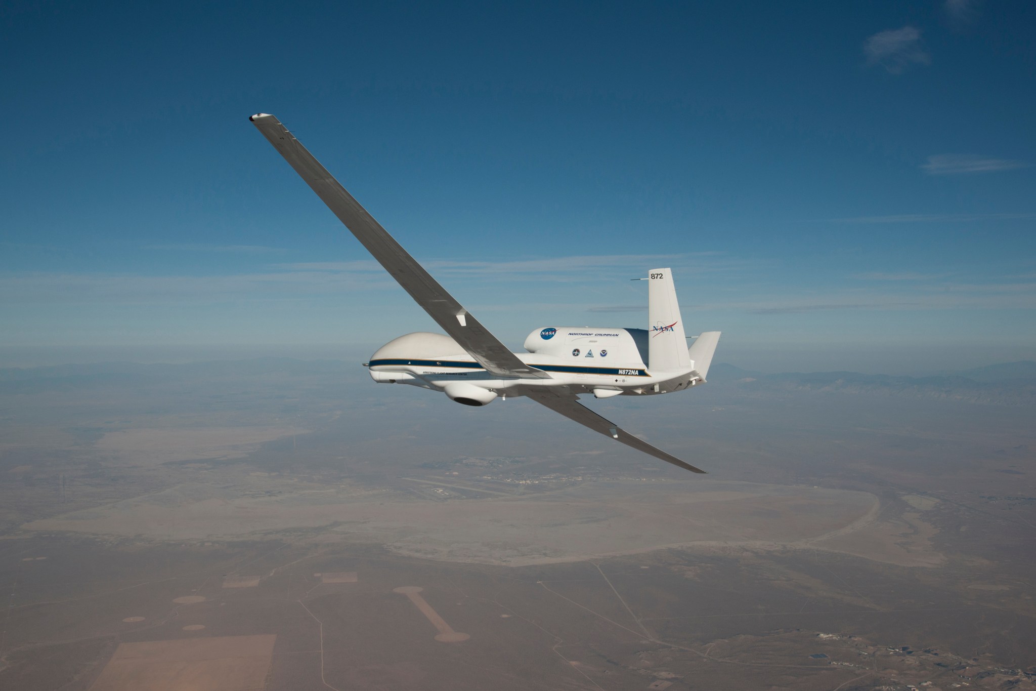 Aircraft with round nose and long, thin wings soars over Edwards Air Force Base.