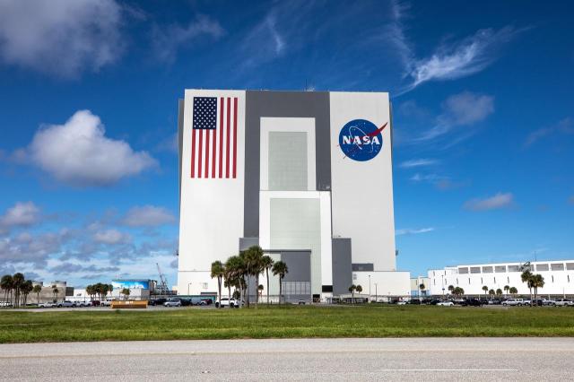 A view of the Vehicle Assembly Building (VAB) with a vibrant NASA logo, referred to as the meatball, and American Flag at NASA’s Kennedy Space Center in Florida on Oct. 27, 2020.