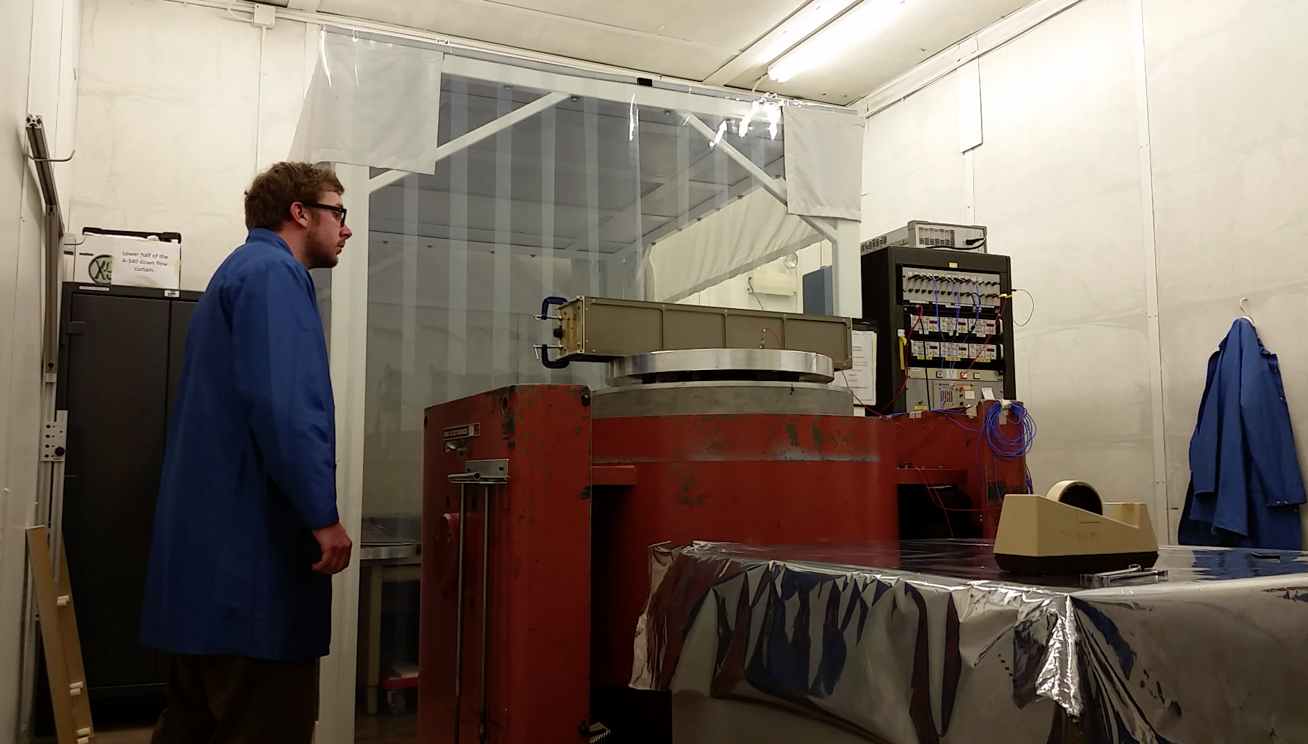 James Mason stands on the left, looking at the Miniature X-Ray Solar Spectrometer, which sits on a table on the right.