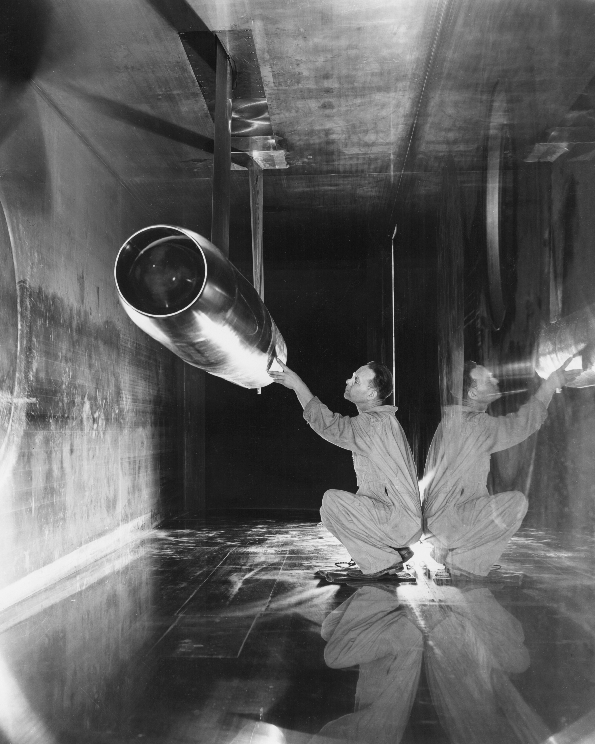 A black and white photo of a NASA employee inspecting the NACA 16 inch RAM jet.