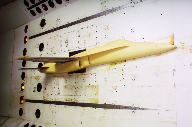 Half of a yellow model of a semi-span fighter model being tested in the Transonic Dynamics Tunnel.
