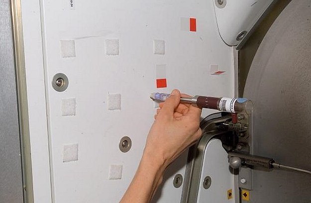 Astronaut Sunita Williams uses the swabbing unit to collect samples that will be placed into the cartridges