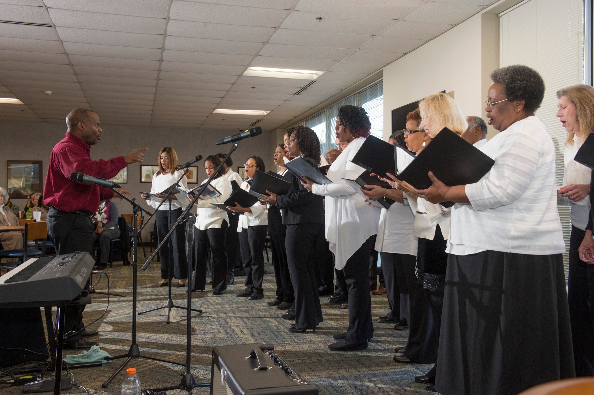 Marshall engineer Kim Jones, left, leads the Voices of Marshall Chorus in song Feb. 11 in the Building 4203 cafeteria.