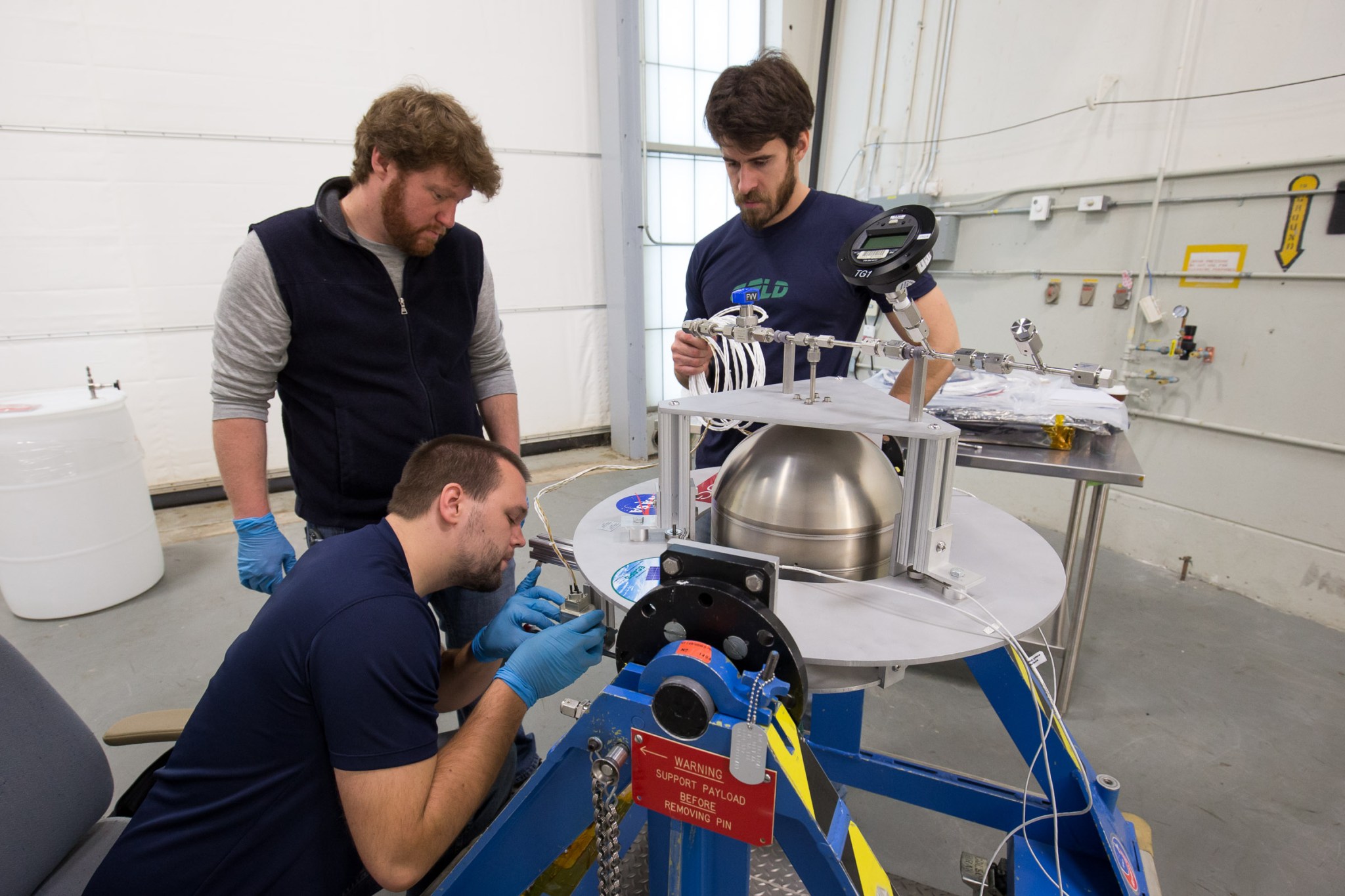 A Goddard team prepares a tank containing a Swedish-developed green propellant.