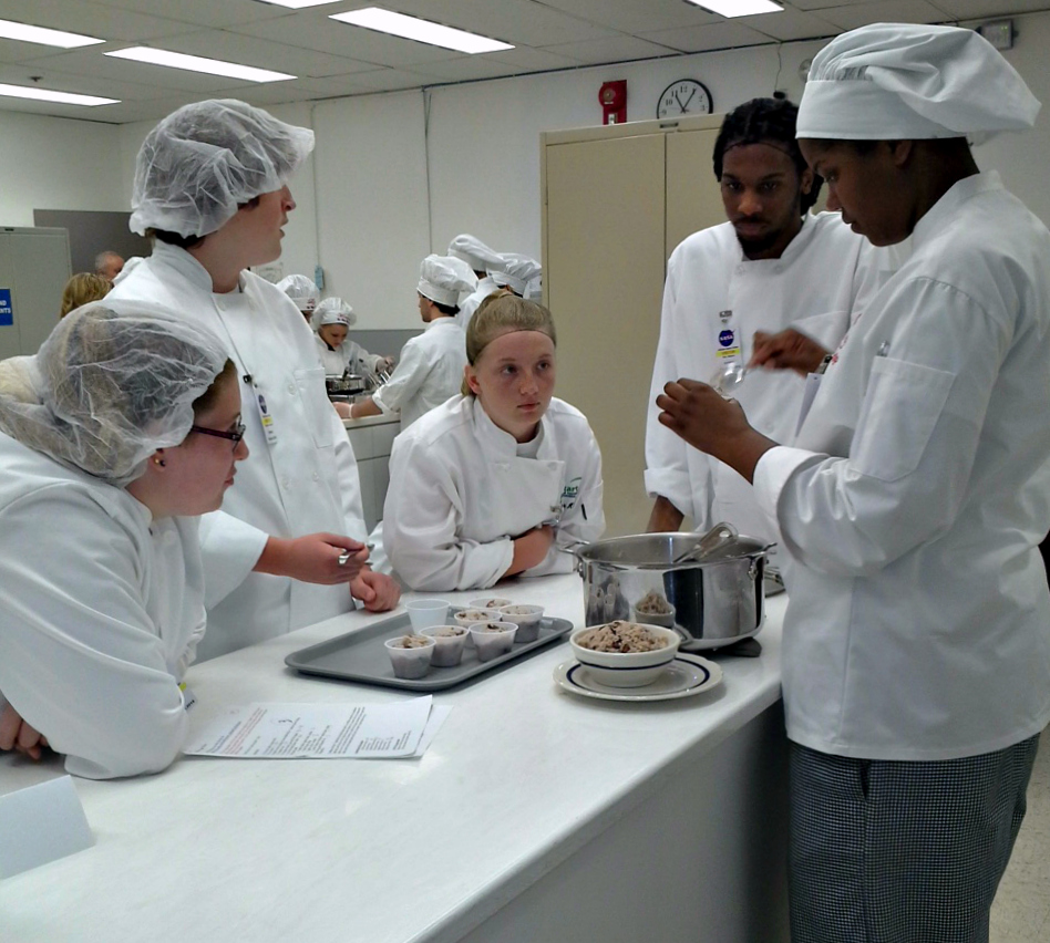 Students from the Phoebus team work on their recipe in a kitchen