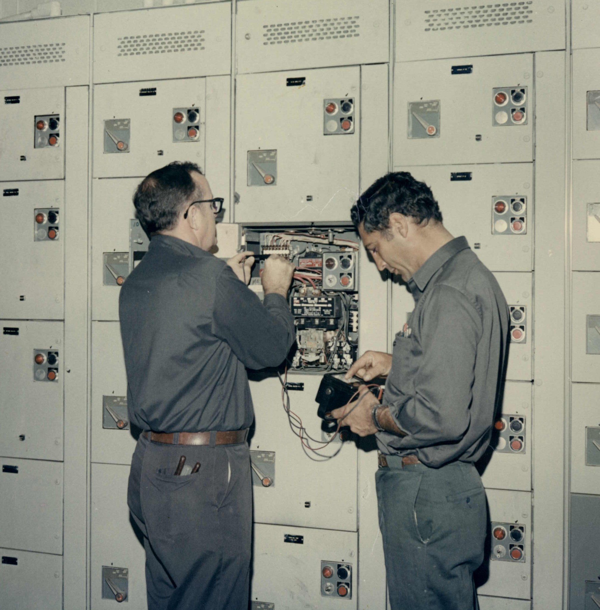 Global Associates employee Andy Anderson (l) and a colleague make repairs to a motor control center at the Mississippi Test Faci