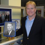 Portrait of Jackson "Jack" Balch Jr., posing with a photo of his father.