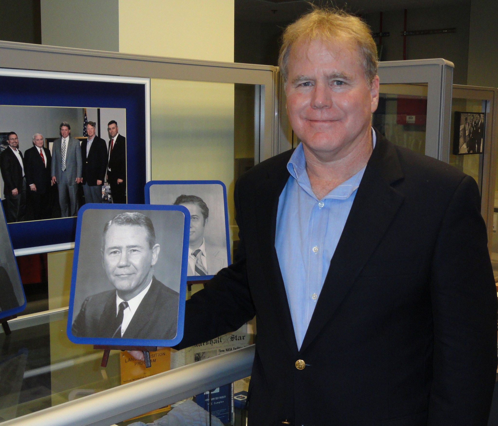 Portrait of Jackson "Jack" Balch Jr., posing with a photo of his father.