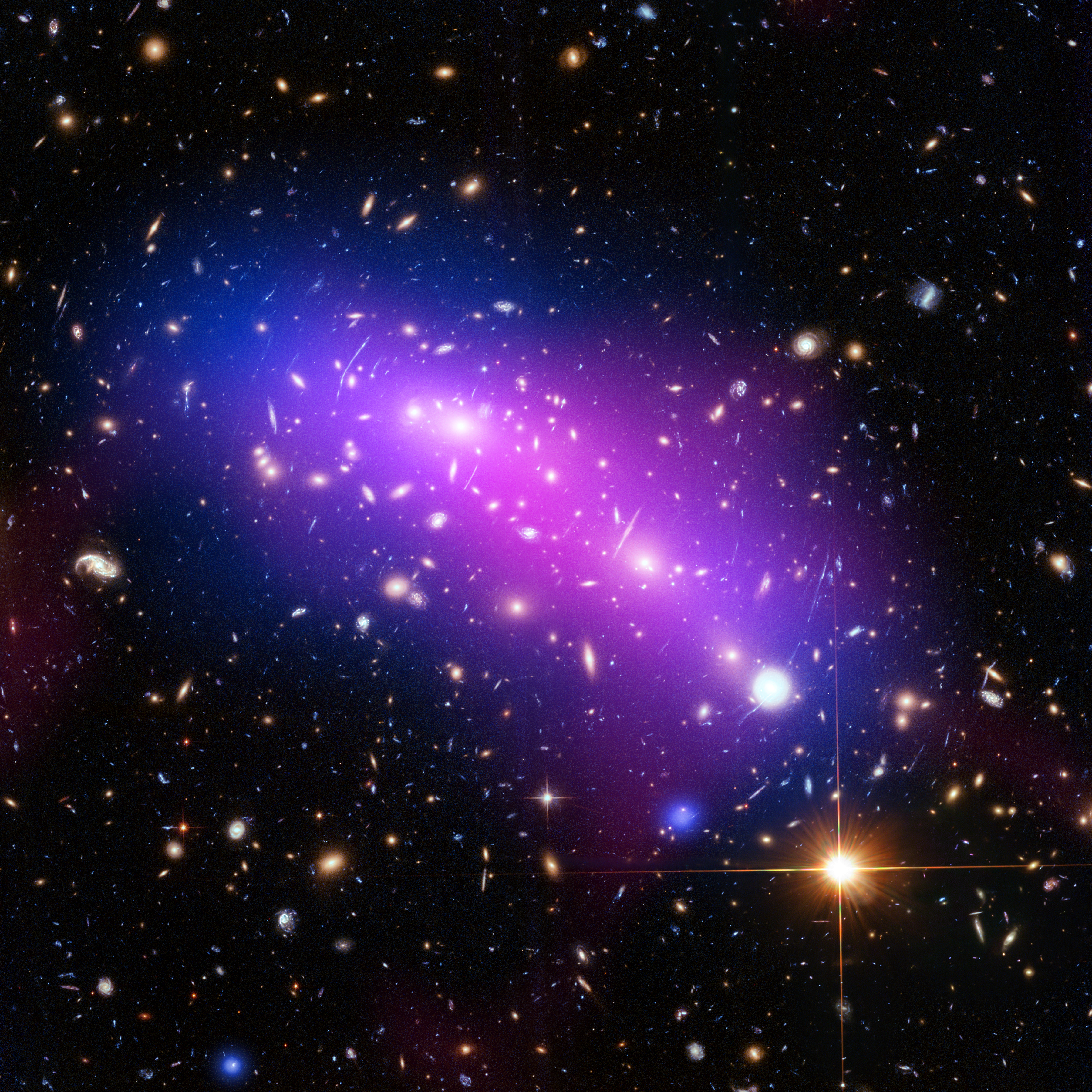 A Chandra image of the Frontier Fields galaxy cluster MACS J0416. The image shows tightly-packed galaxies of all shapes and sizes -- spirals, ellipticals, and more -- against a sparser field. Some of the galaxies in the cluster appear as thing strips, the result of gravitational lensing. The cluster is shrouded in a purple haze, representing hot gas. There are also several field stars in the foreground, with diffraction spikes.