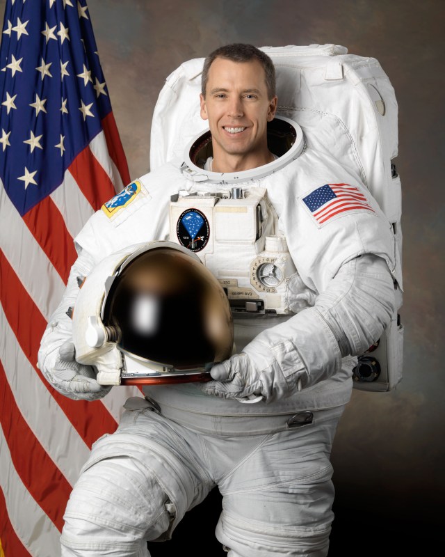 Astronaut Andrew Feustel wearing a spacesuit posing for his official NASA portrait.