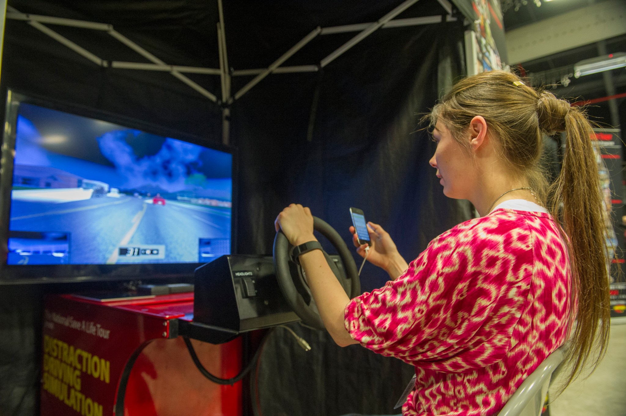 Marshall accountant Marissa Key takes part in a distracted-driving demonstration, a key element of SHE Day 2016 activities. 