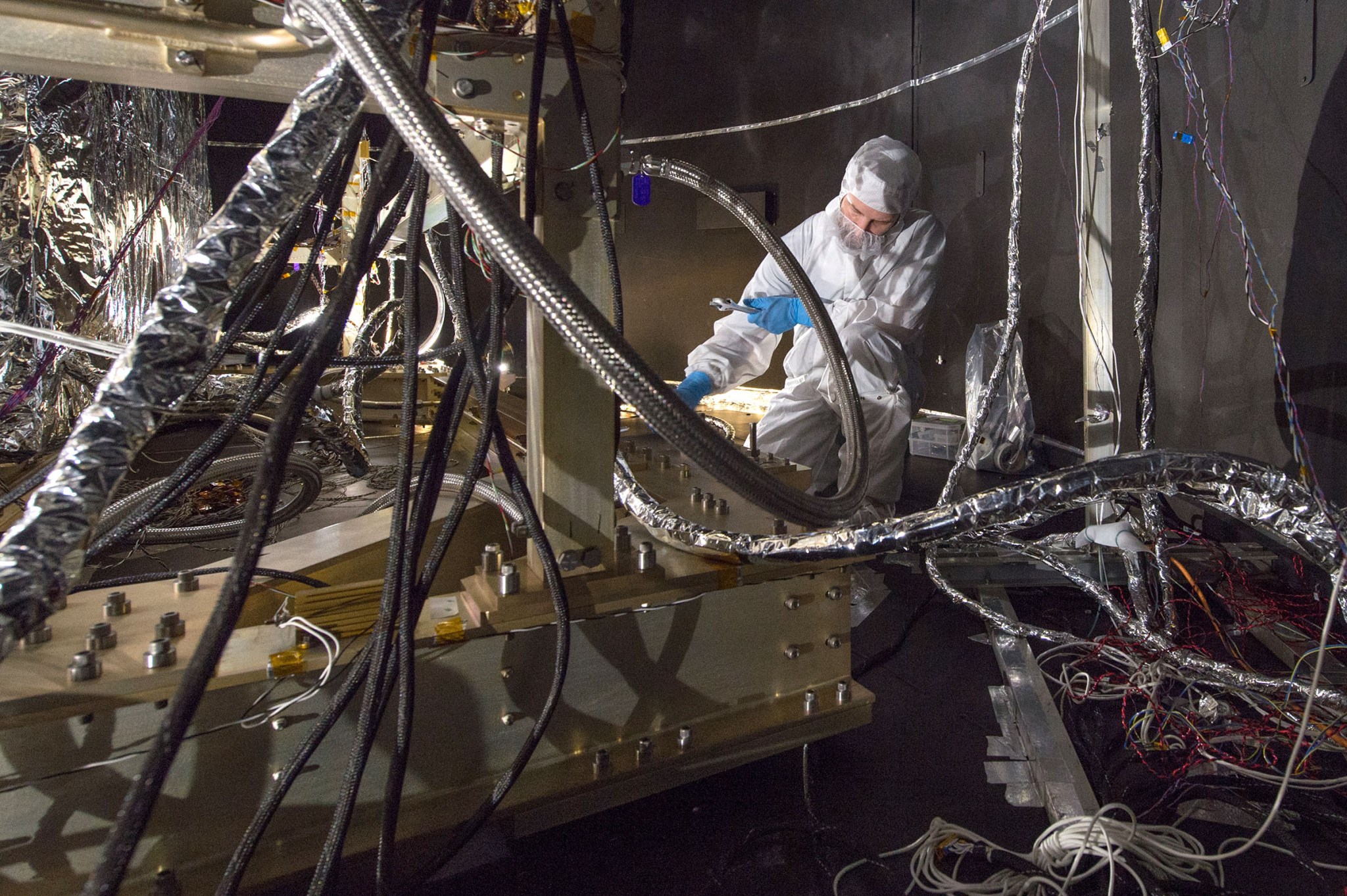 Technician installs thermal blankets to the underside of the James Webb Space Telescope test model