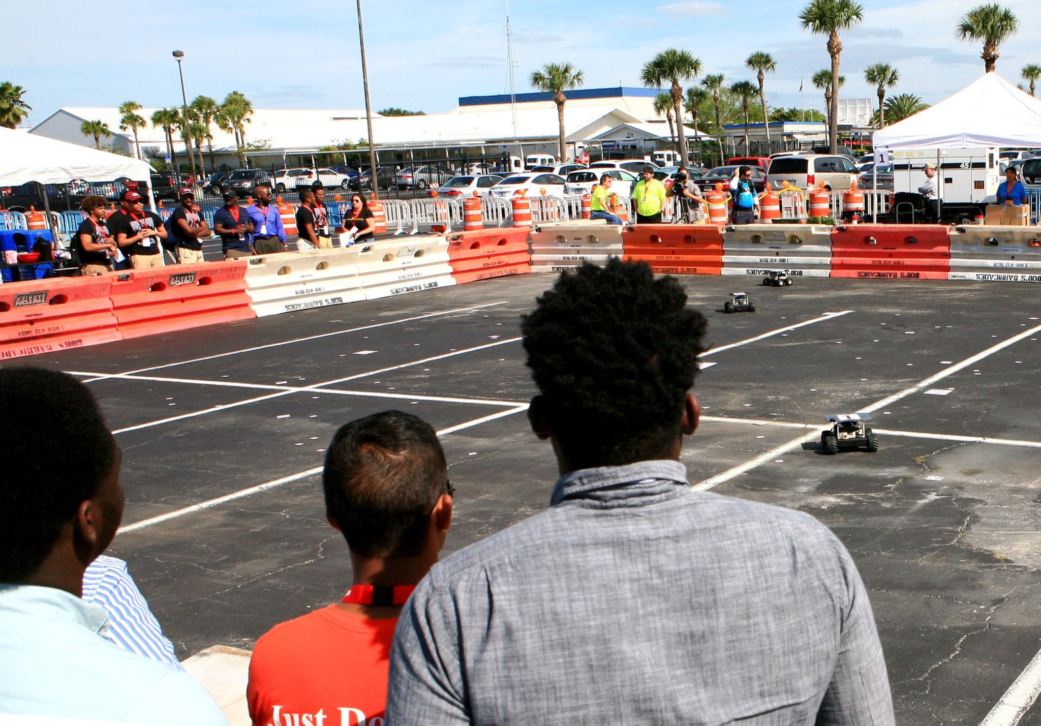 College and university student teams watch as Swarmies search