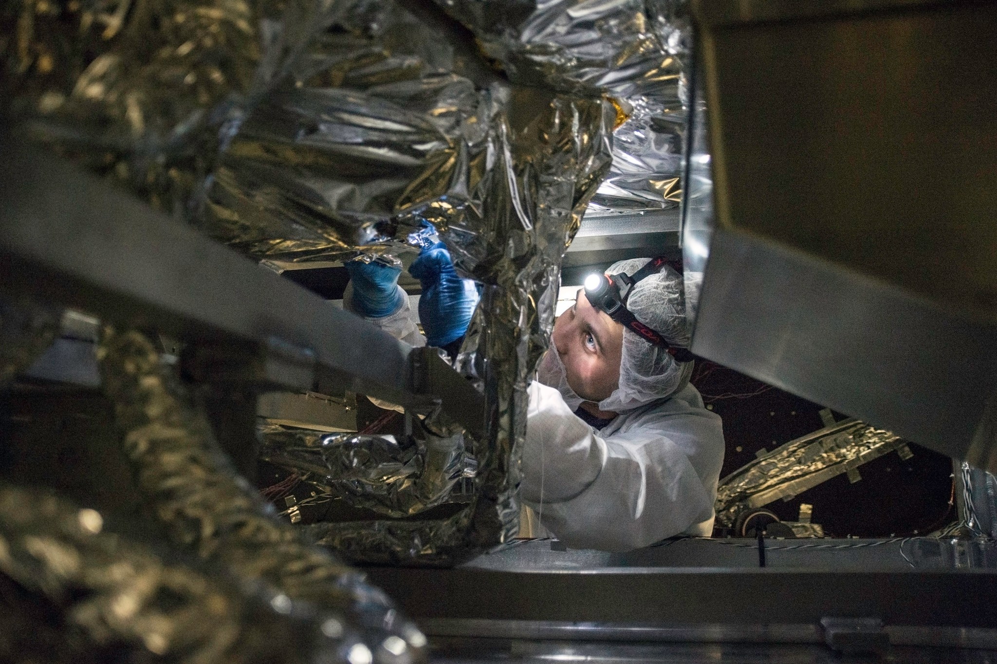 A technician works with a flashlight under the test model