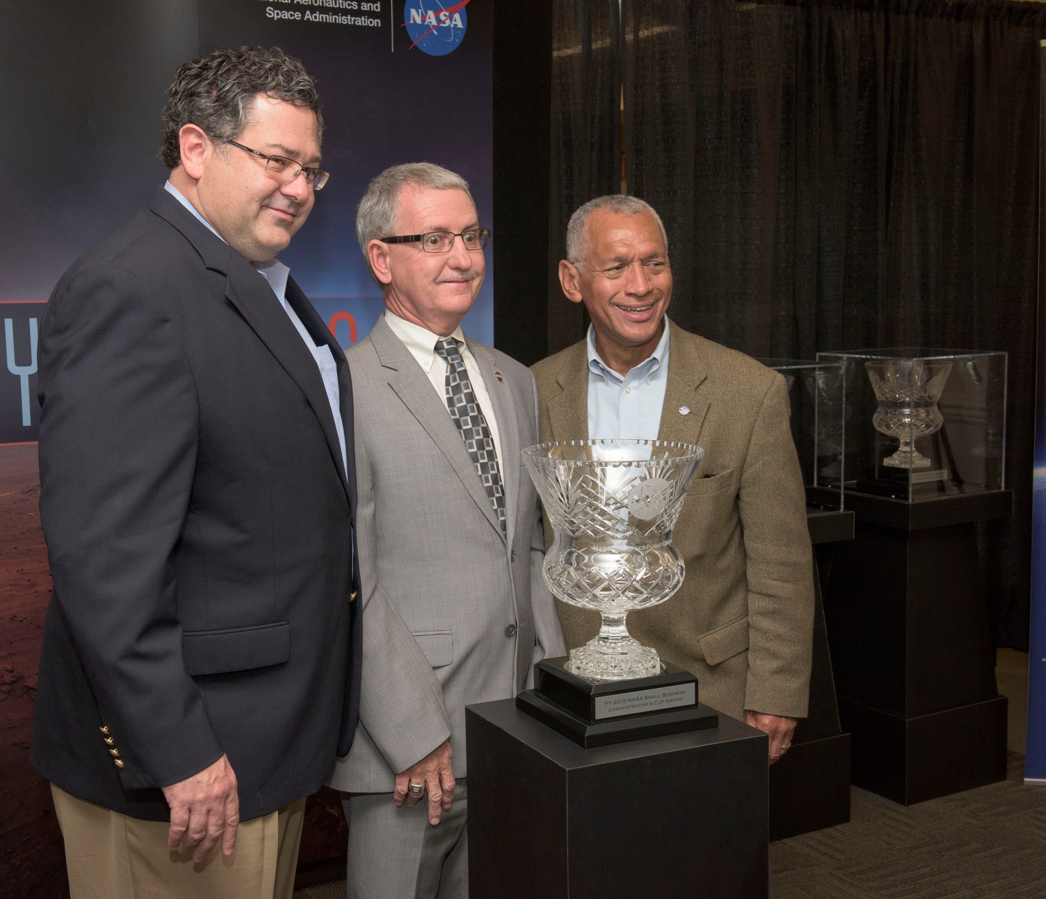 From left, Todd May, David Brock and Charles Bolden, NASA administrator, pose with the 2016 Small Business Administrator’s Cup.