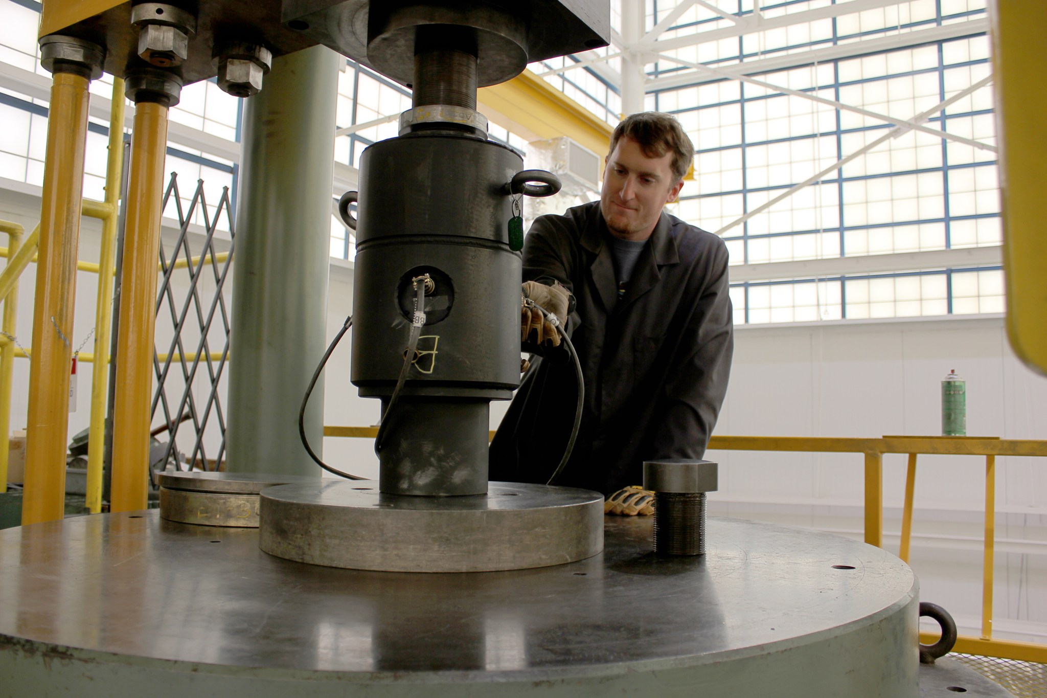 Metrology technician Joey Longino stands on the top of a Gilmore machine prior to starting the calibration process.