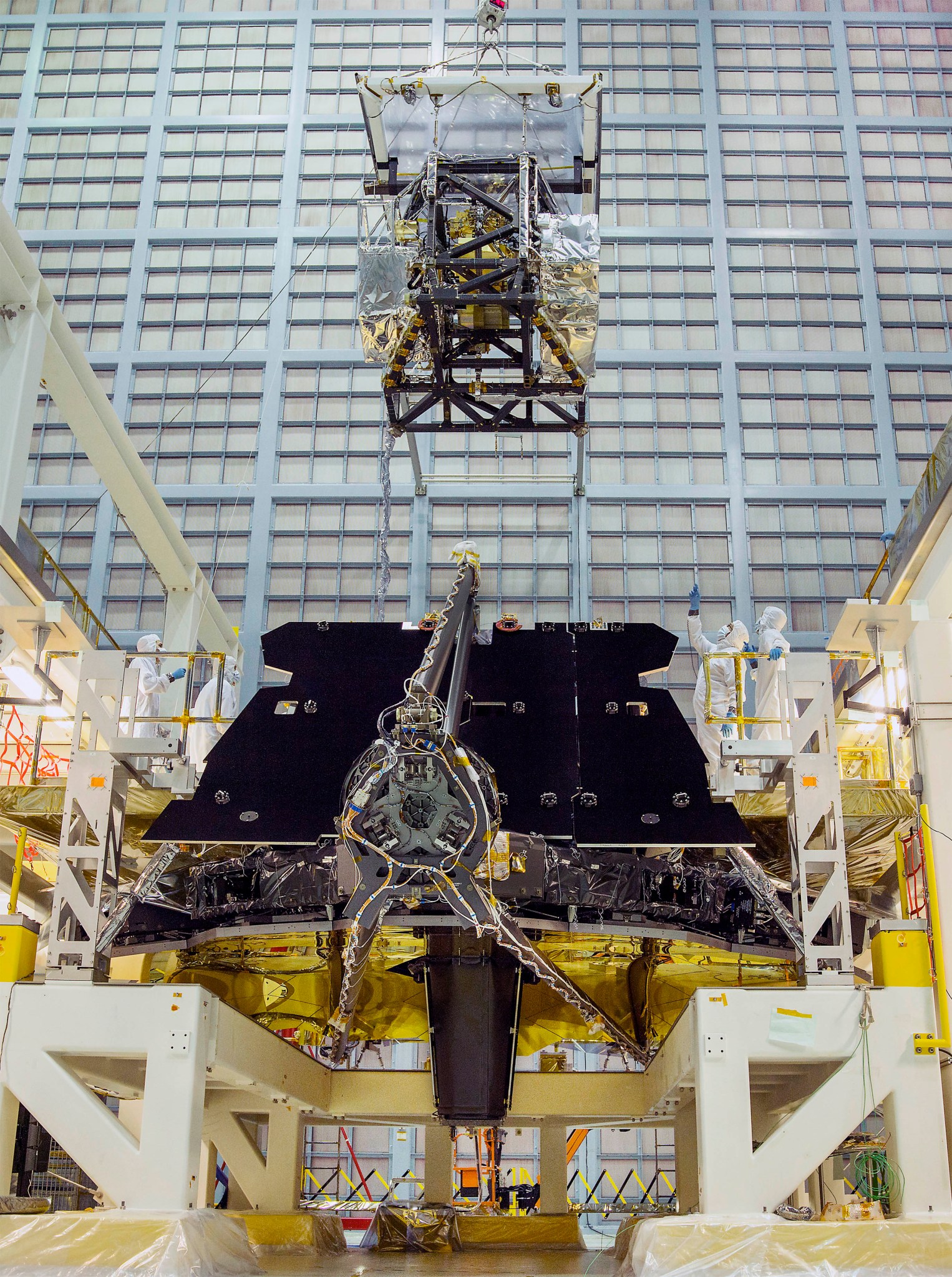 In this rare view, the James Webb Space Telescope team crane lifted the science instrument package for installation into the tel