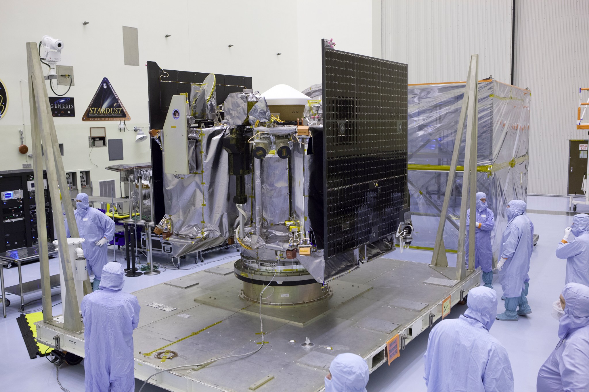 People in protective suits surround a spacecraft