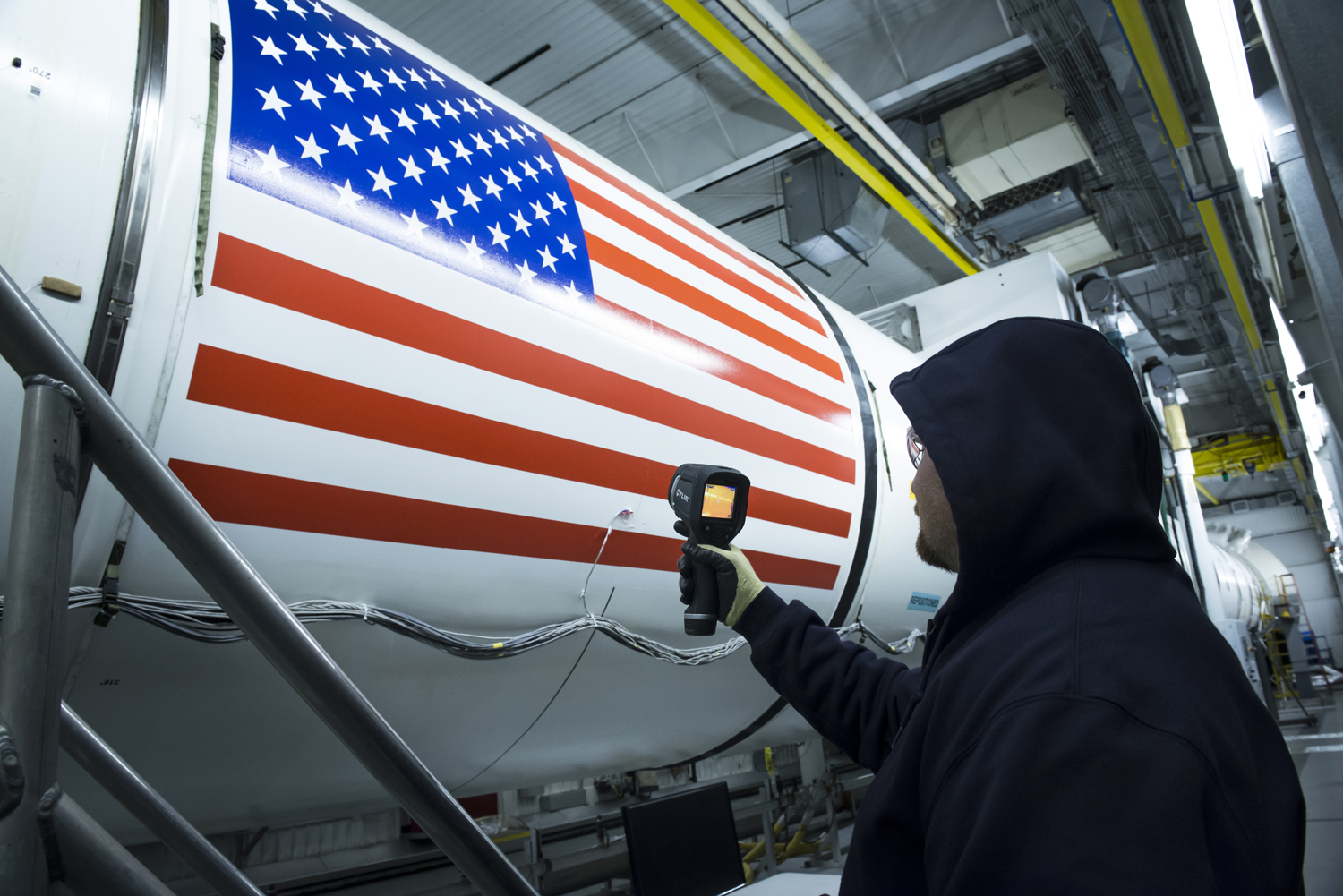 An Orbital ATK technician checks the temperature of a full-scale, test version booster for NASA's new rocket