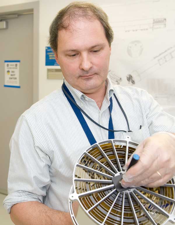 Researcher holding cylindrical x-ray mirrors.