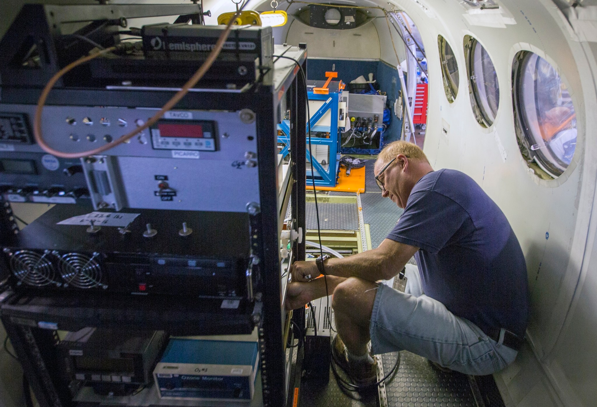 Technician Jim Plant checks an instrument rack aboard the King Air B-200 at NASA's Langley Research Center.