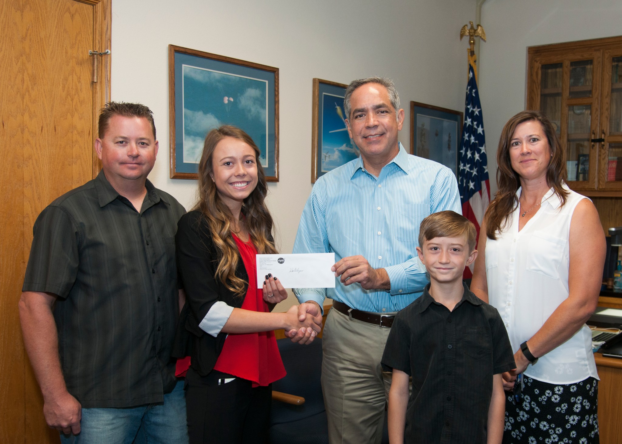 Katelynn Dinius, second from left, accepts the 2016 NASA Armstrong Exchange Thomas W. Finch Scholarship from Center Director Dav