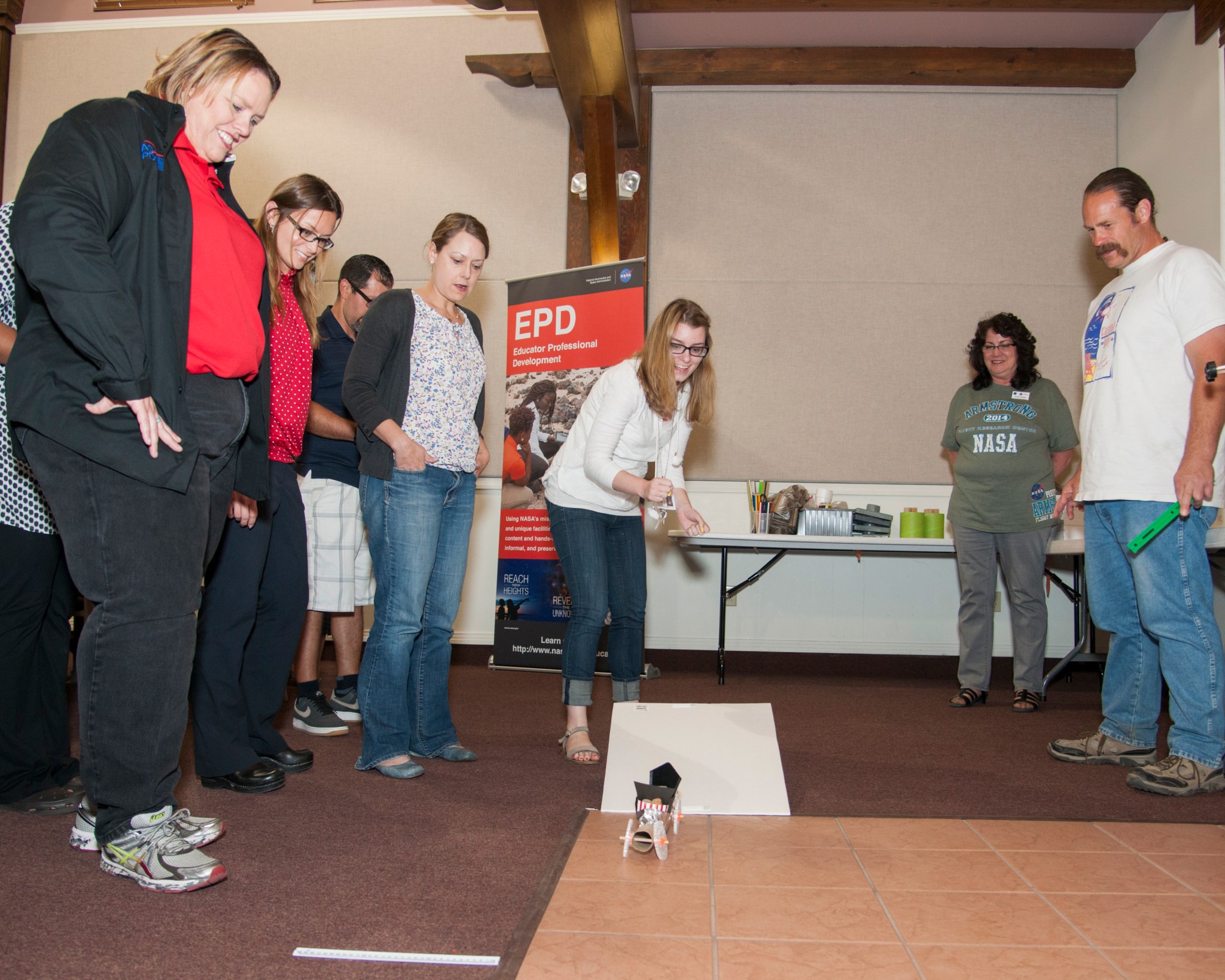 Armstrong education specialist Barbie Buckner (far left) watches workshop participants test a Mars rover they built. 