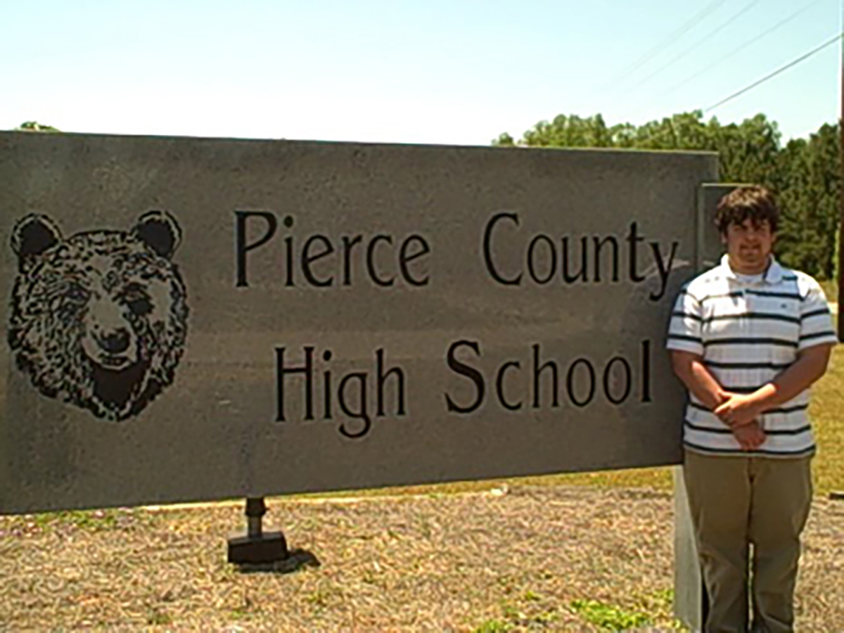 Bryant Barnes standing next to the Pierce County High School sign.