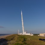 A sounding rocket launches from Wallops Island against a blue sky.
