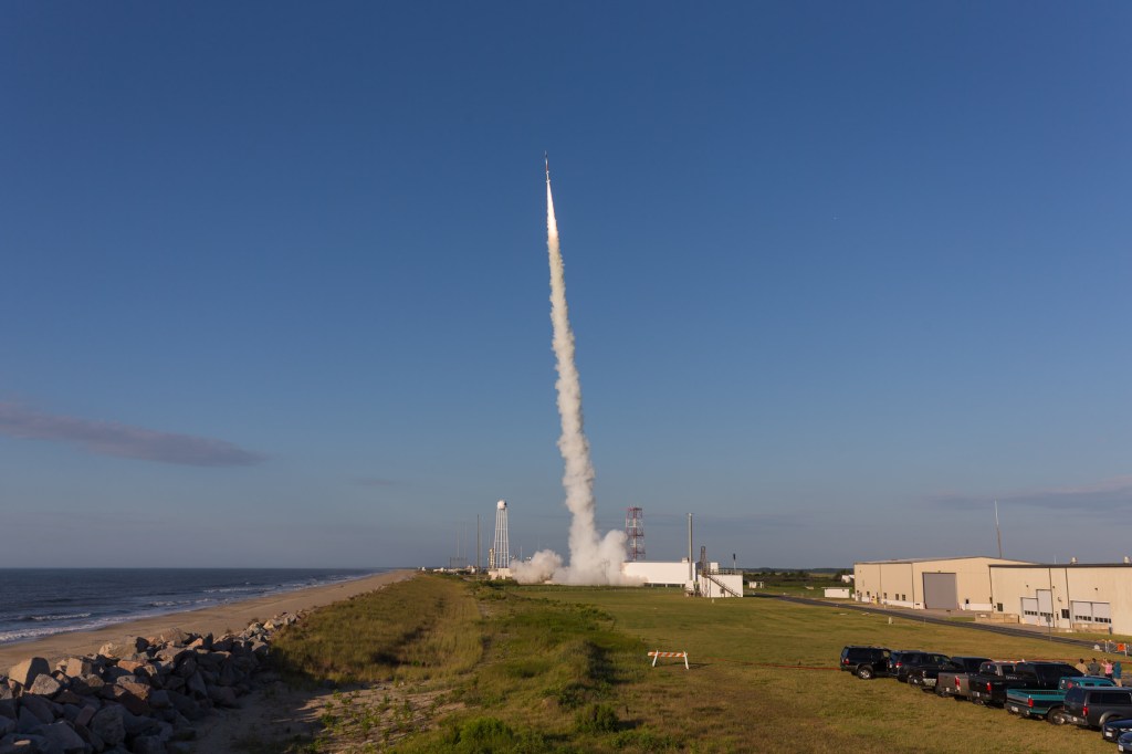 A sounding rocket launches from Wallops Island against a blue sky.