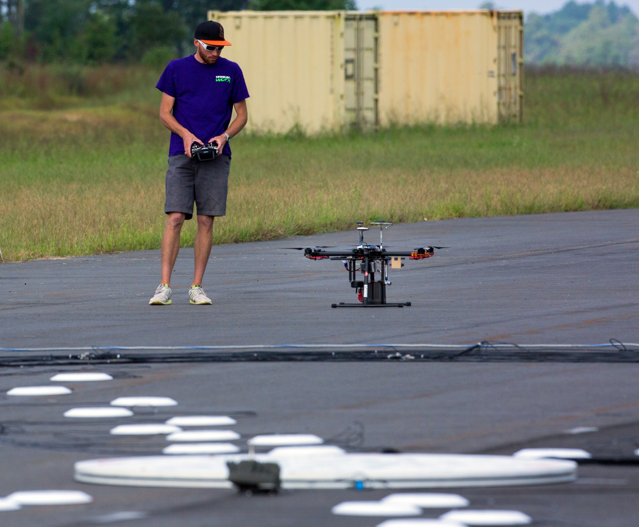 Pilot Zak Johns checks out a hexacopter before its flight over the acoustics array (in foreground).