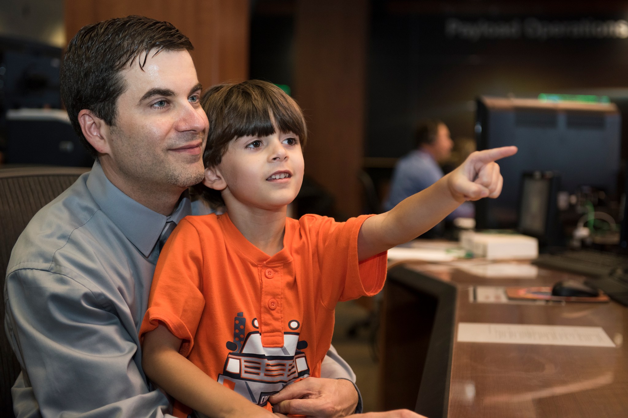 Norwood gives his 5-year-old son Camden a quick behind-the-scenes look at  the Payload Operations Center.