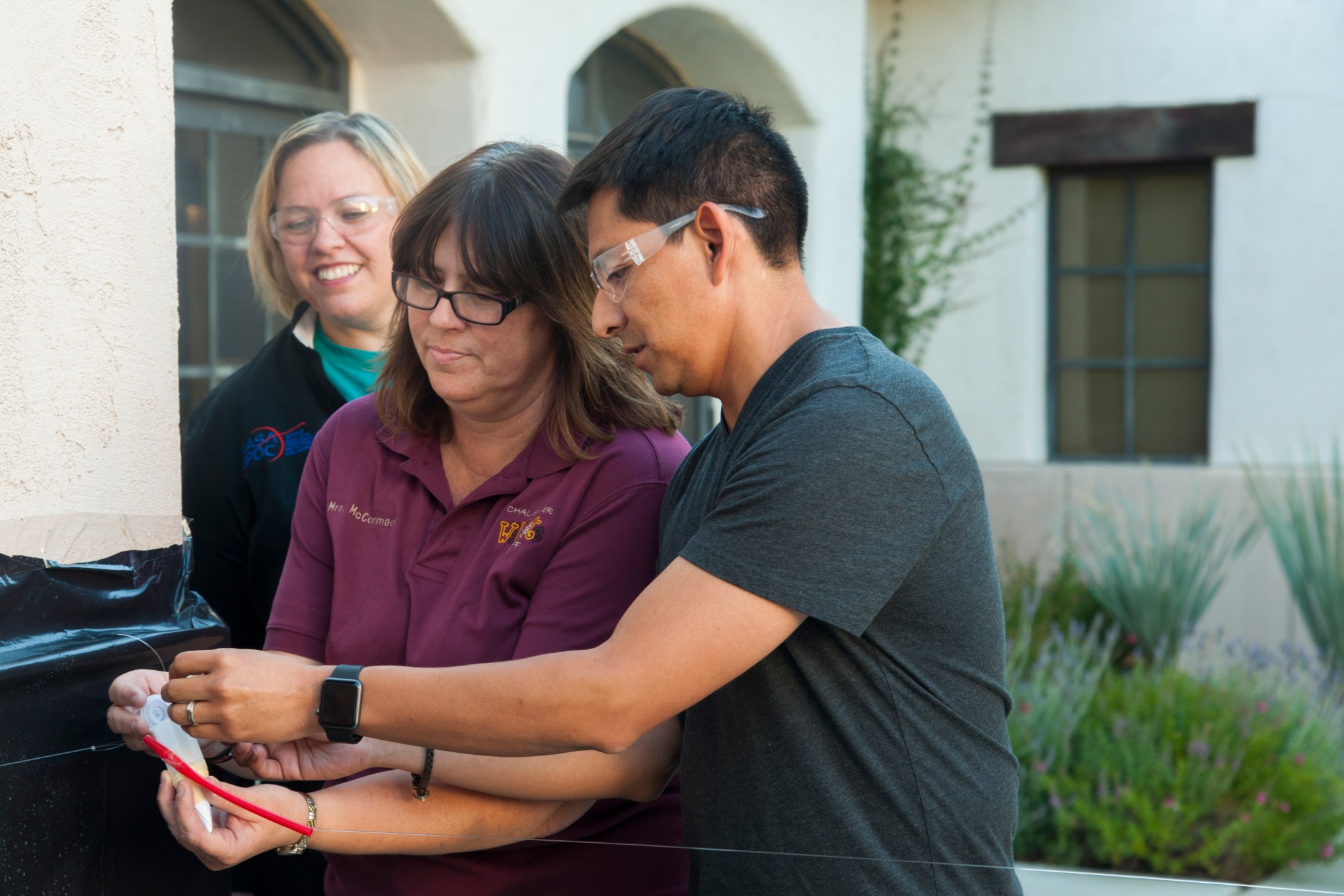 Educators prepare to launch a model spacecraft as Armstrong education specialist Barbie Buckner watches.