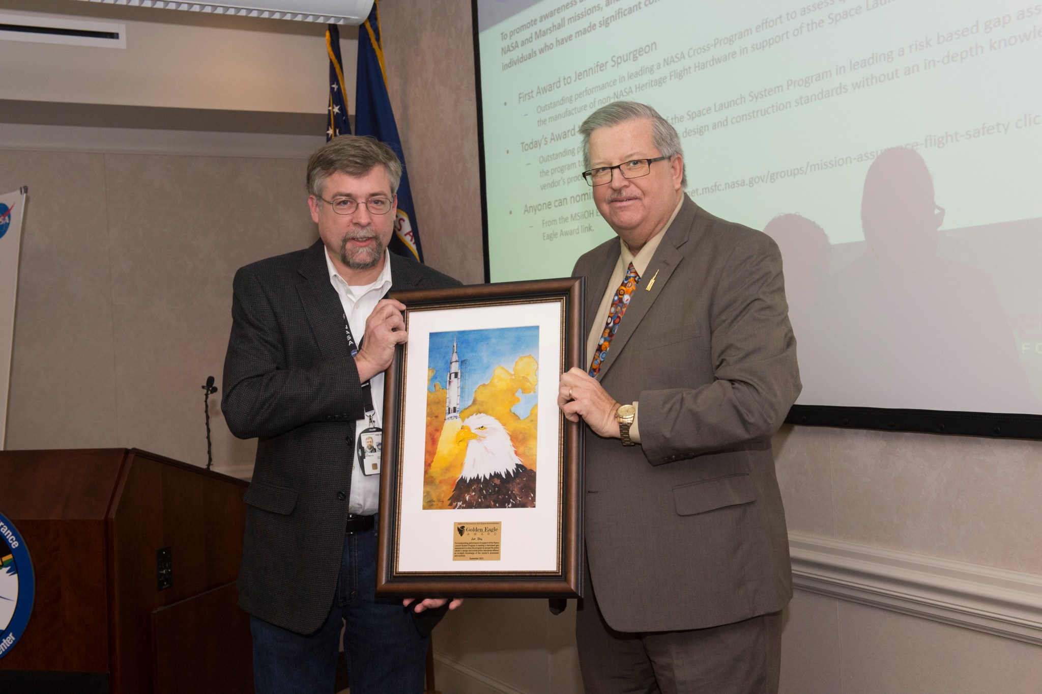 Jeff Dilg, left, is presented the Golden Eagle Award by Steven Pearson at a Feb. 24 Shared Experiences forum.