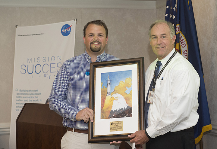 Joel Hobbs, left, is presented the Golden Eagle Award by former SMA Director Steve Cash at an April 28 Shared Experiences forum.