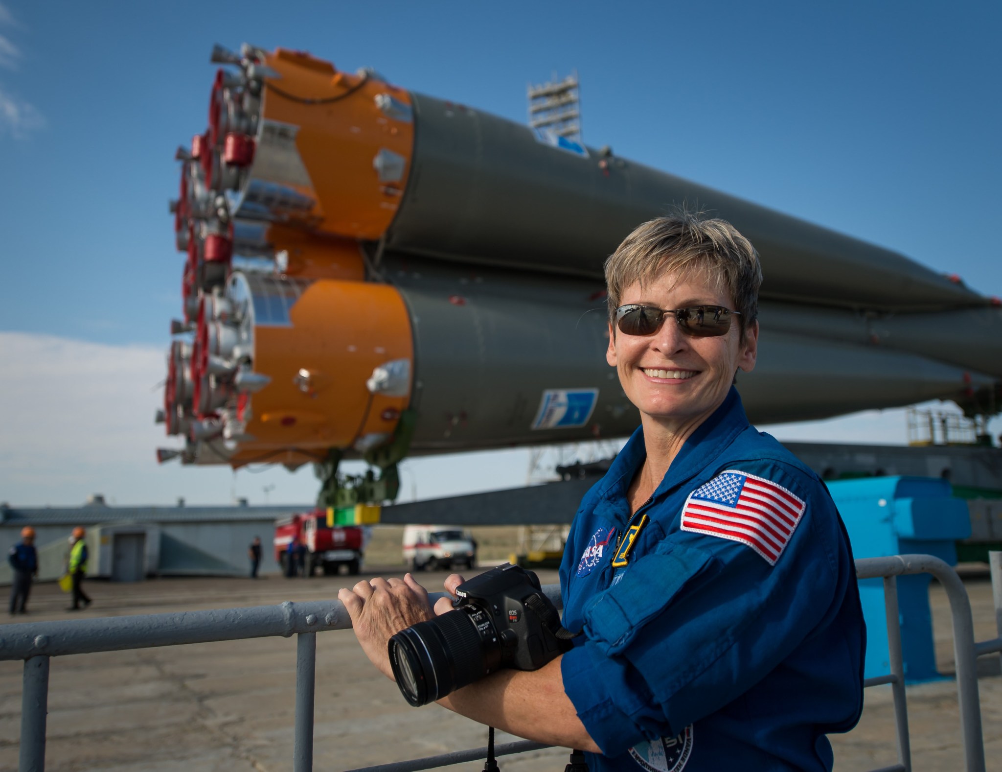 NASA astronaut Peggy Whitson stands in front of a Soyuz rocket 