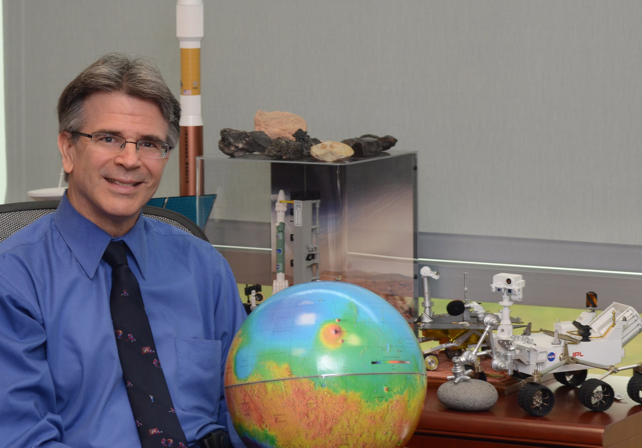 Garvin in his office next to a model of the Mars Orbiter Laser Altimeter (MOLA), a 1980s experiment that employed the first lase