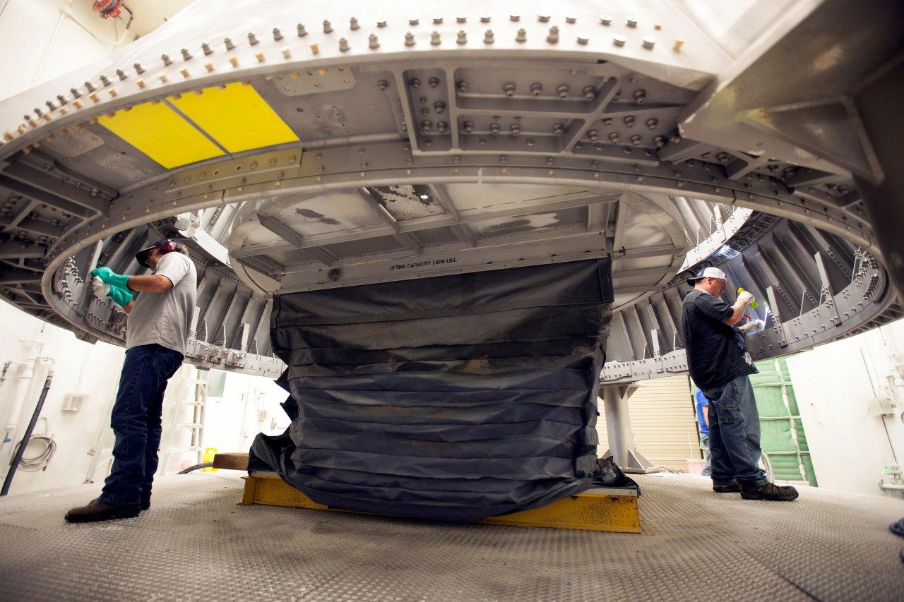 Technicians prepare the right-hand aft skirt for primer and painting.