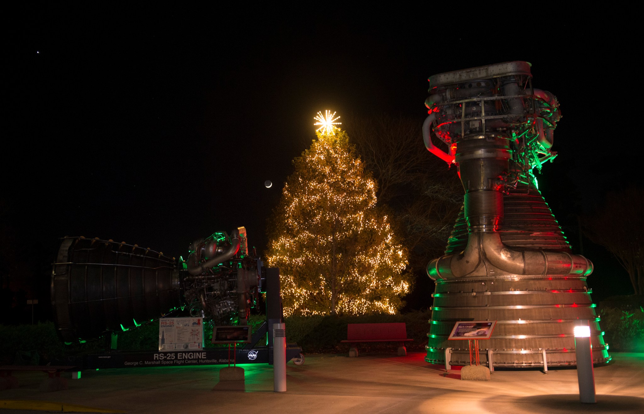 Marshall's newly lit holiday tree is flanked by iconic NASA rocket engines outside Building 4200.