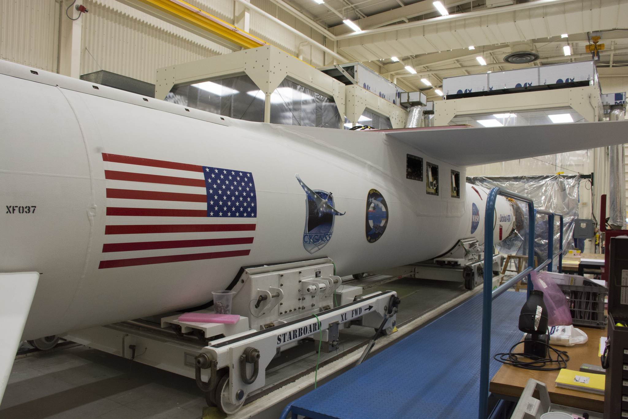 The Orbital ATK Pegasus XL rocket bearing the CYGNSS mission patch undergoes payload fairing installation at Vandenberg.