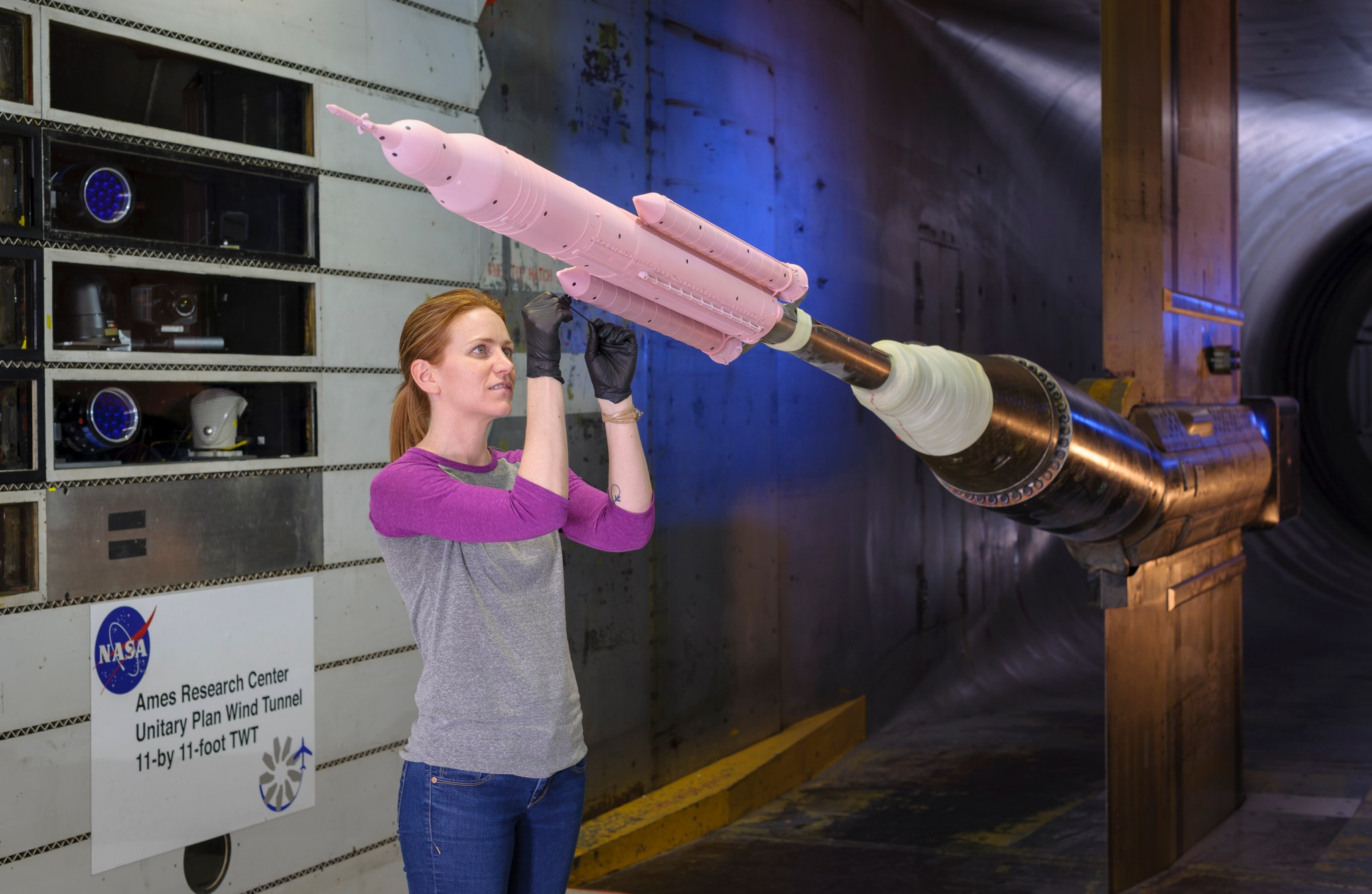 A model of the Space Launch System rocket is prepared for testing with pressure-sensitive paint in a wind tunnel at NASA Ames.