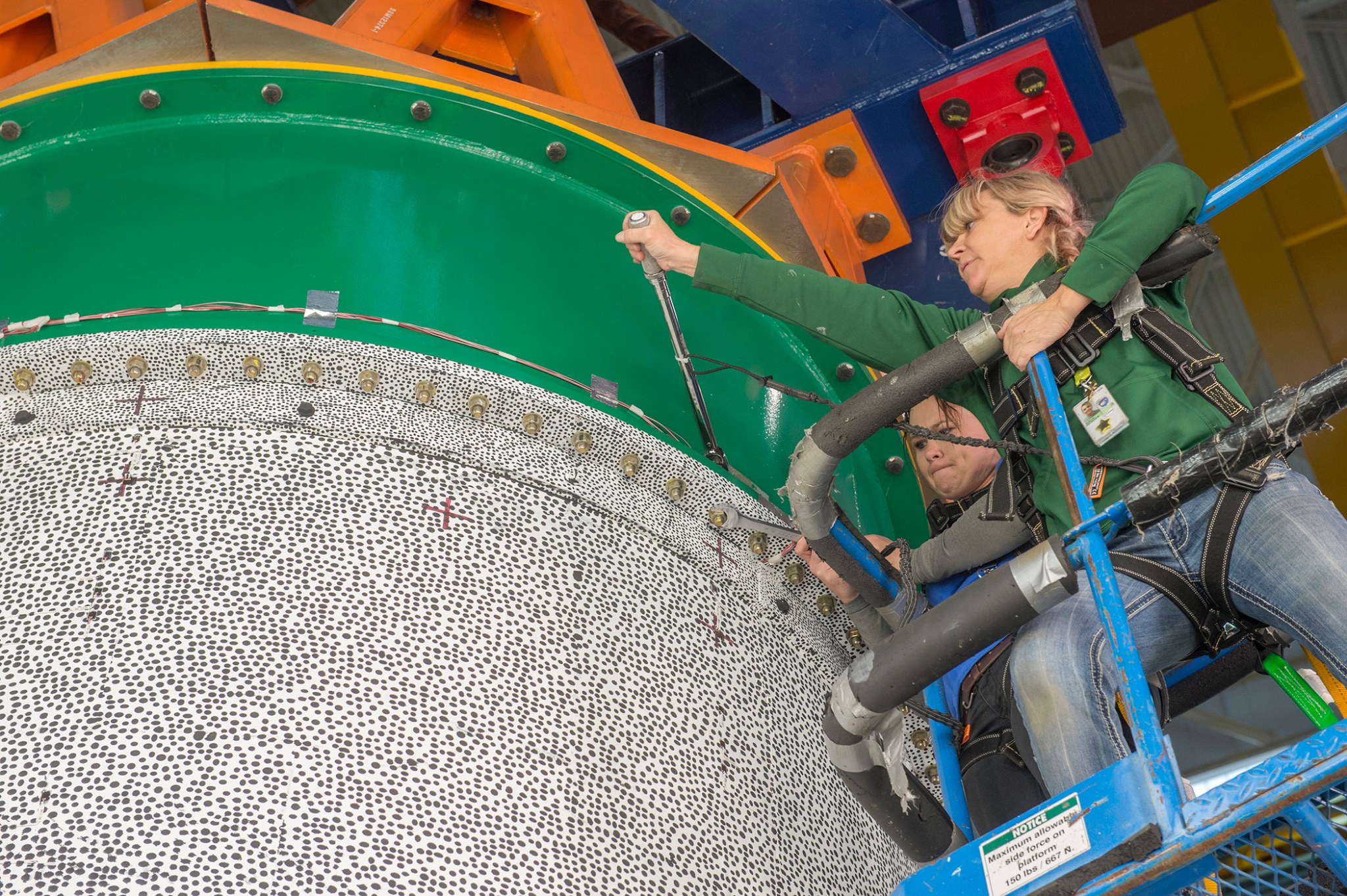 Kathryn Guelde and Ashley Holladay, right, work to install the structural test article for the first series of composite tests.