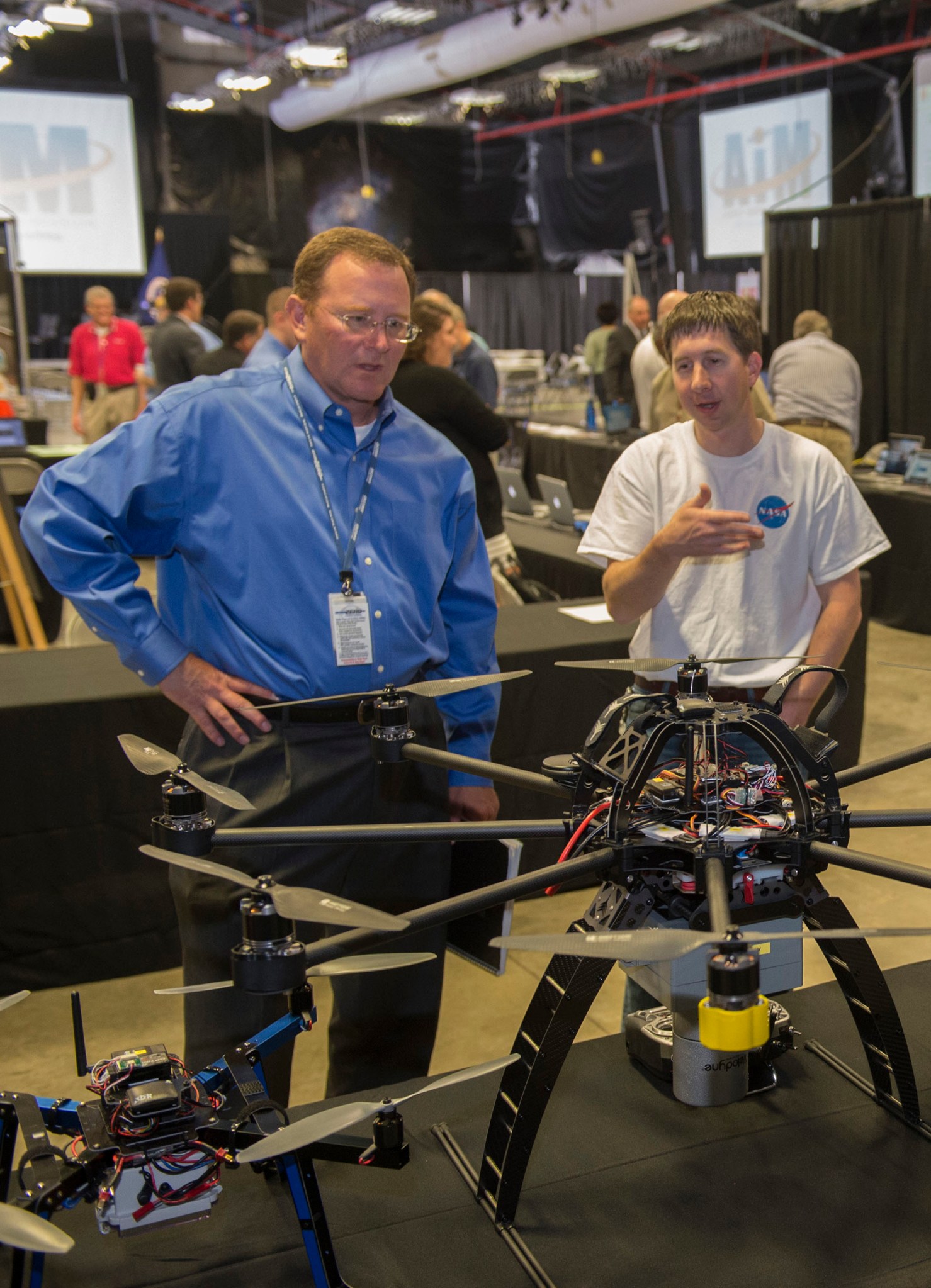 Andy Johnston, left, and Garrick Merrill discuss the Unmanned Aerial and Ground vehicles at Agency Innovation Mission Day.