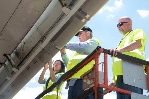 NASA researcher analyzing aircraft wing after coatings test flight.